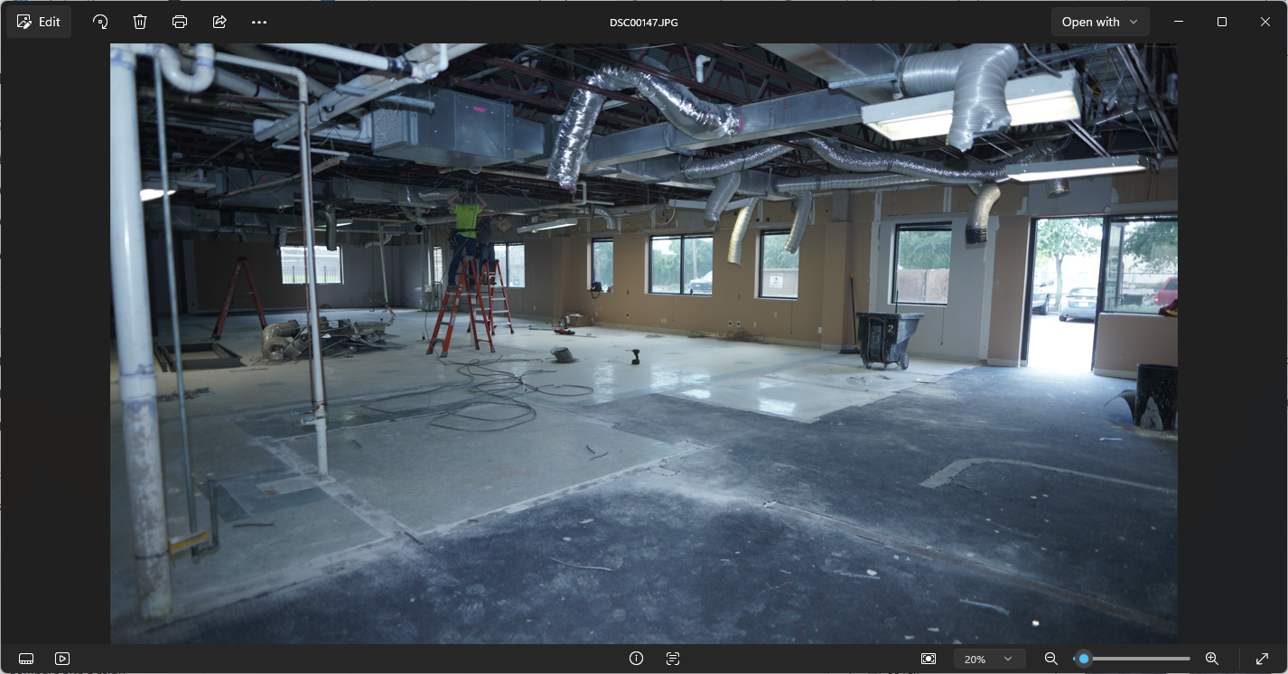 Active interior commercial construction with exposed HVAC and trades working